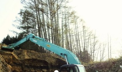 山あいで掘削する重機