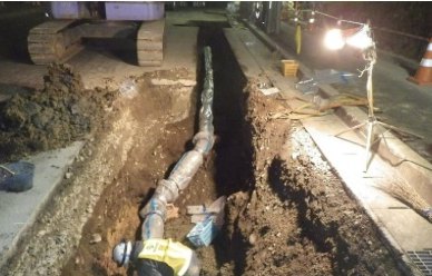 夜間に配水管を布設する作業員